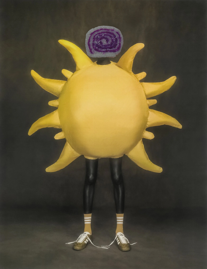 model in untied adidas gucci shoes and socks wearing matching yellow sun costume